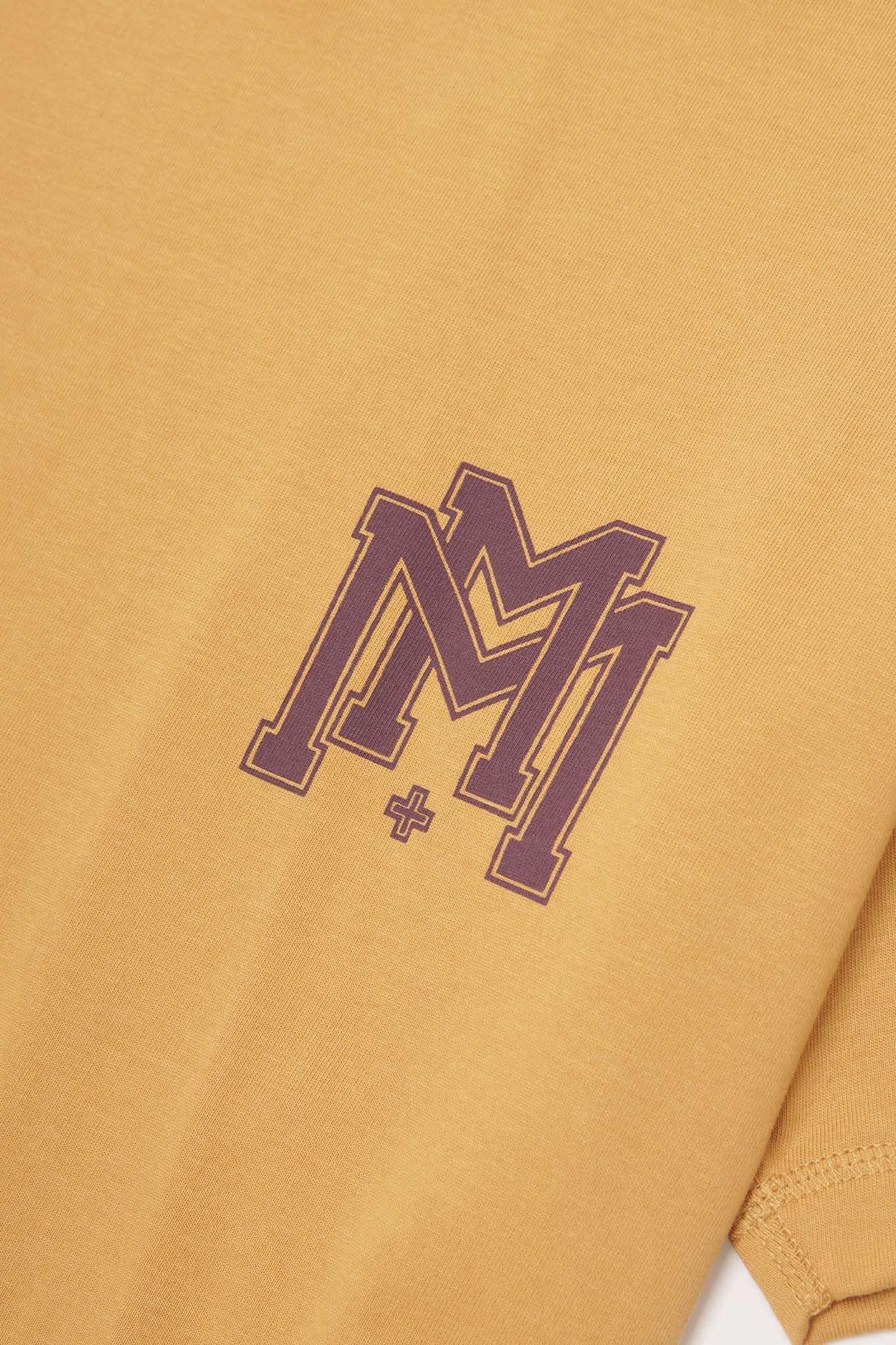 M'$ UNIVERSITY V2 TEE IN MUSTARD